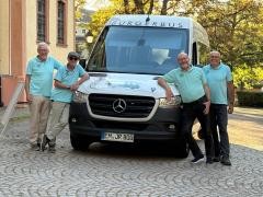 Neben dem Bürgerbus haben sich mehrere Fahrer aufgestellt und lächeln in die Kamera.