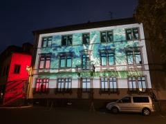 Das Bürgerhaus wird von außen mit einem Video beleuchtet.